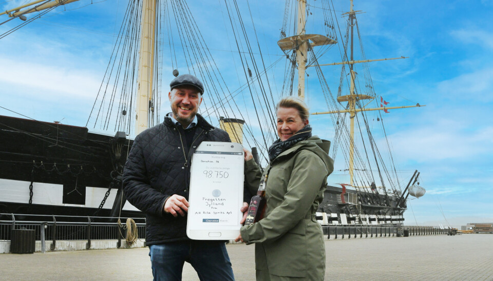 Fregatten Jyllands Arrangements & Butikskoordinator Connie Riddersholm får overrakt donationen af A.H. Riise Spirits direktør, Micheal Bielefeldt.