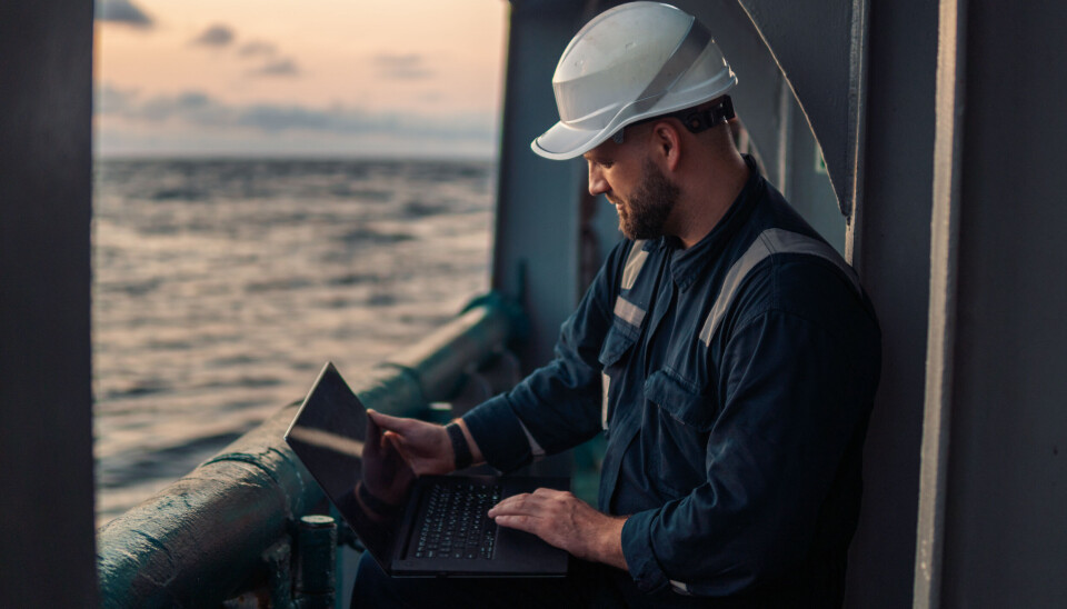 Marine chief officer or captain on deck of vessel or ship watching laptop. Internet and home connection at sea.